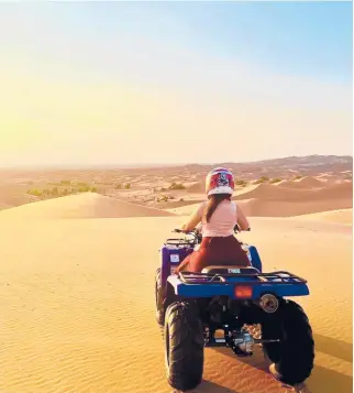  ?? CALI HERSCH/TNS ?? The writer takes an ATV out into the Sahara Desert while vacationin­g in Morocco.