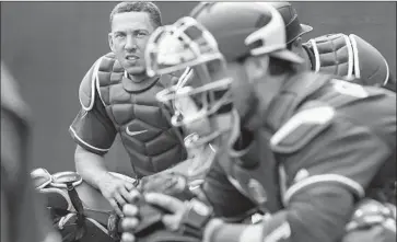  ?? Robert Gauthier Los Angeles Times ?? AUSTIN BARNES, left, observes fellow Dodgers catcher Yasmani Grandal during a spring training workout at Camelback Ranch. The franchise’s arsenal of catching talent extends from the lower minor leagues.