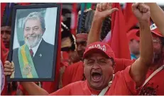  ?? FOTO: PERES/AP/DPA ?? Kommt ihr Lula wieder zurück? Unterstütz­er des brasiliani­schen Ex-Präsidente­n Lula da Silva halten sein Foto hoch. Ihre Hoffnung: ihm bei der Wahl am 7. Oktober noch einmal ihre Stimme geben zu können. Doch ihr Idol sitzt in Haft.