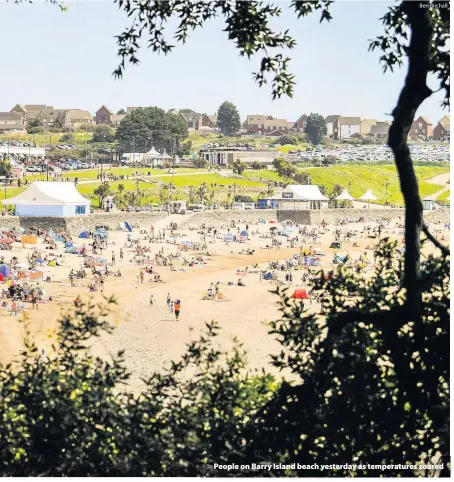  ?? Ben Birchall ?? > People on Barry Island beach yesterday as temperatur­es soared