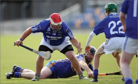  ??  ?? St Pat’s full-forward George O’Brien gathers possession as Carnew’s Diarmuid Doran prepares to get to his feet. Photo: Joe Byrne