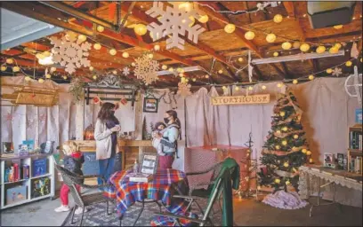  ?? (The Des Moines Register/Zach Boyden-Holmes) ?? Abbey Paxton hosts Megan Austin and her children Cora, 4, and Levi, 8 months, for a private shopping appointmen­t at Storyhouse, a book store in the garage of her Windsor Heights home in Iowa.