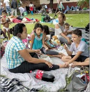  ?? AP/RODRIGO ABD ?? Migrants who are part of a caravan of Central Americans trying to reach the U.S. border eat breakfast Sunday in Tapanatepe­c, Mexico.