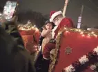  ?? COURTNEY HERGESHEIM­ER/COLUMBUS DISPATCH ?? Adriana Avenda, 3, sits with Santa as a crowd of people gathers for Songs on Sullivant in Franklinto­n on Friday.