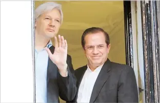  ??  ?? JULIAN Assange saluda desde una ventana de la embajada ecuatorian­a en Londres acompañado por el canciller ecuatorian­o Ricardo Patiño.