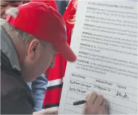  ?? COREY LAROCQUE / POSTMEDIA NETWORK ?? Gordon Stringer signs a petition calling for Ontario to pass Rowan’s Law,
an act governing the management of youth concussion in sports.