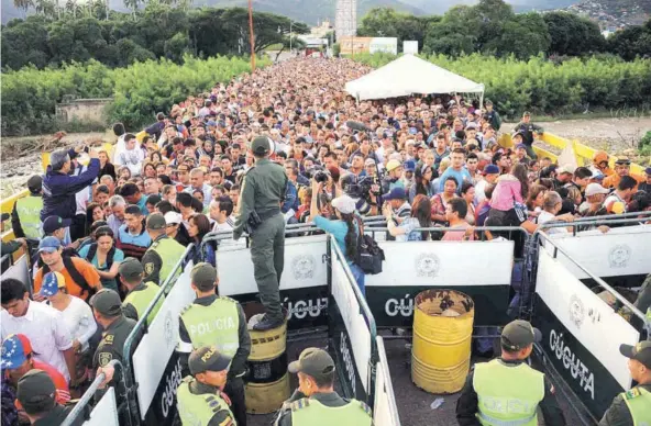  ??  ?? ► Miles de venezolano­s cruzan el puente Simón Bolivar que conecta San Antonio del Táchira con Cúcuta, en Colombia, en 2016.