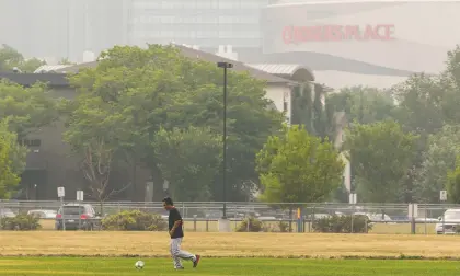  ?? IAN KUCERAK ?? A man plays soccer near Royal Alexandra Hospital Monday as the air quality health index sits at seven, which is considered high-risk.