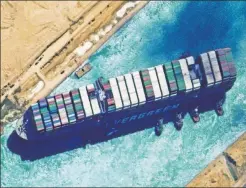  ??  ?? PUSH & PULL: Tugboats push the Ever Given from the Suez Canal’s west bank in a satellite image taken Monday, while a photo from aboard one of the tugs shows the massive vessel finally floating free.