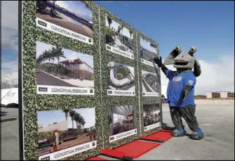  ??  ?? Cosmo, the mascot for the Las Vegas 51s, poses with illustrati­ons depicting the team’s stadium.