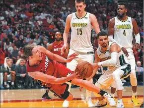  ?? JASEN VINLOVE / USA TODAY SPORTS ?? Miami Heat forward Kelly Olynyk dives to keep the ball in-bounds against the Denver Nuggets during the second half of Monday’s NBA clash in Miami.