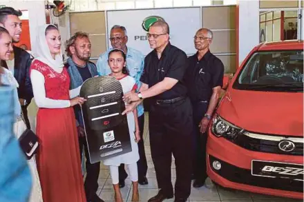  ??  ?? Perusahaan Otomobil Kedua Sdn Bhd president and chief executive officer Datuk Aminar Rashid Salleh (second from right) handing over a mock key to a Bezza buyer in Mauritius yesterday. With him is Raouf Dusmohamud &amp; Co Ltd managing director Raouf Dusmohamud (right).