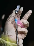  ?? The Canadian Press ?? A registered pharmacist technician fills a Pfizer-BioNTech COVID-19 vaccine in Toronto on Dec. 15.