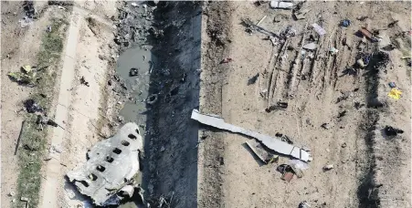  ??  ?? Wreckage from a Ukrainian plane on the ground and in a canal in Shahedshah­r, southwest of Tehran, on Jan 8.