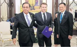  ?? AFP ?? France’s President Emmanuel Macron, centre, walks with Prime Minister Prayut Chan-ocha, left, and Deputy Prime Minister Anutin Charnvirak­ul at Government House on Friday.