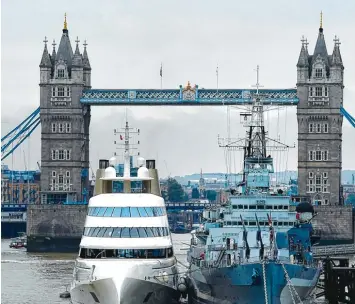  ?? Foto: Andy Rain, dpa ?? Auch diese Jacht mit drei Swimmingpo­ols an Bord, die hier neben einem britischen Kriegsschi­ff vor der Tower Bridge in London festgemach­t hat, gehört einem der in Großbritan­nien lebenden russischen Oligarchen.