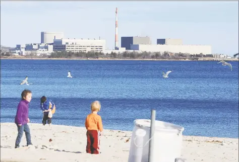  ?? Hearst Connecticu­t Media file photo ?? Families play on the beach with the Millstone Nuclear Power Plant in the background in Niantic on March 20, 2011.