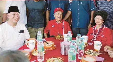  ?? PIC BY MUHAIZAN YAHYA ?? Tourism and Culture Minister Datuk Seri Mohamed Nazri Abdul Aziz (left), Parti Pribumi Bersatu Malaysia chairman Tun Dr Mahathir Mohamad (centre) and his wife Tun Dr Siti Hasmah Mohd Ali having a meal at Dataran Lembah in Kuala Kangsar yesterday.