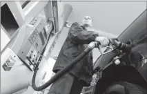  ?? DON RYAN / AP ?? In this May 2015 file photo, attendant James Lewis pumps gas at a station in Portland, Ore. An Oregon law passed nearly seven decades ago banned drivers from pumping their own gas but now that’s changing, in some cases. The new year ushered in some...