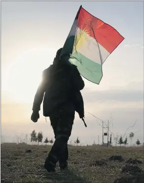  ?? — GETTY IMAGES FILES ?? A peshmerga soldier carries a Kurdish flag in Sinjar, Iraq. Canada’s Liberal government said this week that they’ll be increasing military support for Kurds in the northern part of Iraq.