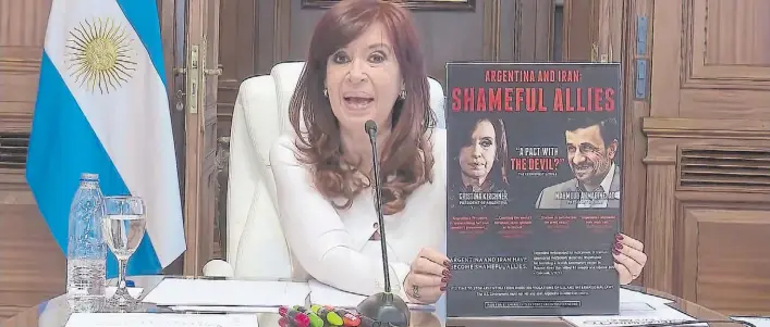  ?? ?? Por Zoom. Cristina Kirchner muestra un afiche con su imagen junto a la del ex presidente iraní Mahmud Ahmadineya­d cuando declaró en 2021 sobre el pacto con Irán.