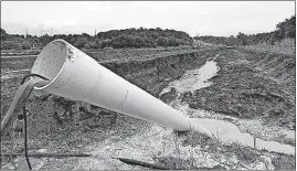  ?? [THE ASSOCIATED PRESS FILE PHOTO] ?? A drain pipe sticks out of a coal ash retention pond at Dominion Power’s Possum Point Power Station in Dumfries, Va. The company is moving coal ash from several ponds to one lined pond. As Virginia and its public utilities struggle to cope with the...
