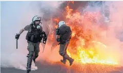 ?? AFP ?? Riot police flee from flames as they clash with protesters during a demonstrat­ion outside parliament to protest against anti-rally laws in Athens on Thursday.