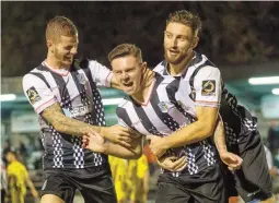  ??  ?? Josh Kelly is mobbed by teammates after scoring a spectacula­r overhead kick against AFC Fylde last season.