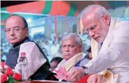  ?? PTI ?? Prime Minister Narendra Modi looks at a lotus flower as Union minister Arun Jaitley looks on at the BJP National Council Meeting in Kozhikode on Sunday. —