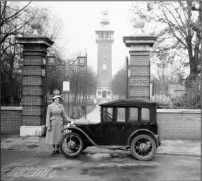  ??  ?? Ann Holubecki (nee Hopper) outside Loughborou­gh’s Queen’s Park gates with a friend’s vintage car, with the Carillon in the background. Collection of Ann Holubecki.
