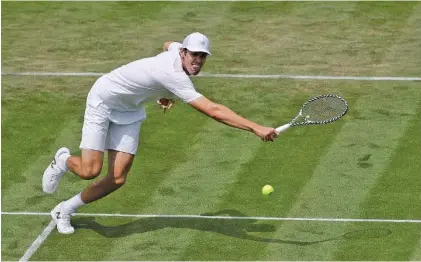  ?? AP PHOTO/BEN CURTIS ?? Reilly Opelka returns a shot to Stan Wawrinka during a second-round match at Wimbledon on Wednesday. Opelka, a 21-year-old American playing in just his fourth Grand Slam tournament, beat three-time major champion Wawrinka in five sets, 7-5, 3-6, 4-6, 6-4, 8-6.