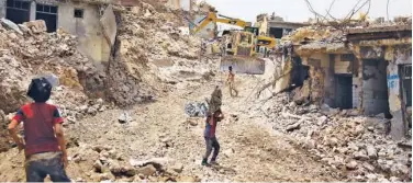  ??  ?? A tractor clears debris in Mosul. File / Agence France-presse