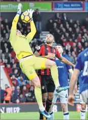 ??  ?? Everton's goalkeeper Jordan Pickford jumps to claim the ball under pressure from Bournemout­h's striker Callum Wilson during their EPL match in Bournemout­h on Saturday. The match ended in a 1-1 draw.