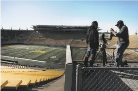  ?? Liz Hafalia / The Chronicle ?? Foxaffilia­ted broadcast technician Francisco Del Rosario (left) and camera operator Ron Frison set up a camera at California Memorial Stadium in Berkeley on Thursday in preparatio­n for Friday’s Big Game.