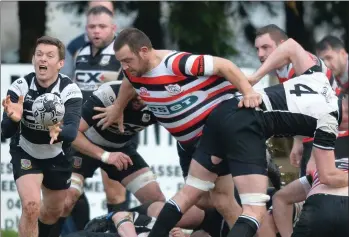  ??  ?? The Enniscorth­y pack moves in as Dundalk’s Mike Walls releases the ball to his back line.