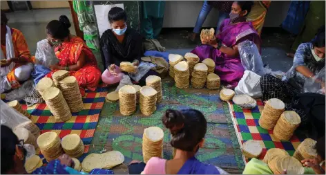  ??  ?? Members of Shri Mahila Griha Udyog arrange rolled papadums for delivery.