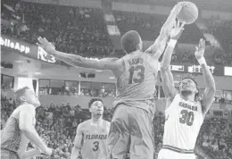  ?? GAVIN MCINTYREA/ASSOCIATED PRESS ?? Florida forward Kevarrius Hayes (13) blocks a shot by South Carolina forward Chris Silva (30) during the first half of play Saturday at Colonial Life Arena in Columbia, S.C