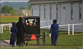  ?? (File Photo/AP/Jessie Wardarski) ?? Families of the Old Order Stauffer Mennonite Church in New Holland, Pa., arrive in May by horsedrawn buggy for their first in-person church service in nearly two months due to the coronaviru­s.