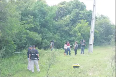  ??  ?? Policías de Investigac­iones del área Central, junto con los agentes de Criminalís­tica, acordonaro­n el lugar donde encontraro­n el cuerpo de la mujer, que estaba tirado boca arriba entre unos árboles.