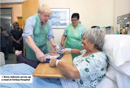  ??  ?? > Boris Johnson serves up a meal at Torbay Hospital