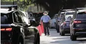  ?? JOSE A. IGLESIAS jiglesias@elnuevoher­ald.com ?? A guard keeps cars moving at Sunset Elementary in Miami as parents drop off children at the school on Wednesday.