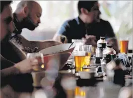  ?? Photog r aphs by
Luis Sinco
Los Angeles Times ?? PATRONS at Beachwood BBQ and Brewing in Long Beach get drinks served in different glass shapes, the better to showcase each beer’s unique qualities.