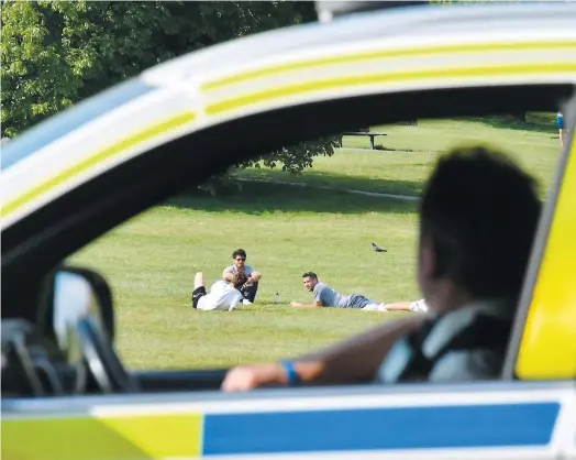  ?? PHOTO AFP ?? Un policier observe les interactio­ns entre les gens rassemblés sur la colline Primrose Hill, à Londres.