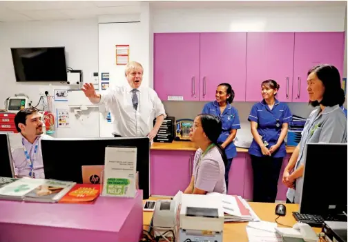  ?? File/ Reuters ?? British Prime Minister Boris Johnson gestures as he speaks to Dr Sarah Bowdin at the National Institute for Health Research at the Cambridge Clinical Research Facility, in Addenbrook­e’s Hospital in Cambridge, Britain.