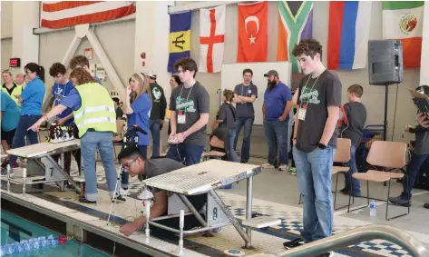  ?? (Special to The Commercial/University of Arkansas Division of Agricultur­e) ?? One of the winning teams, the Grant County Aquanauts, works together to steer their ROV through the mission course. Members are Garrett Key (from left), Priyam Laxmi and Eli Watson.