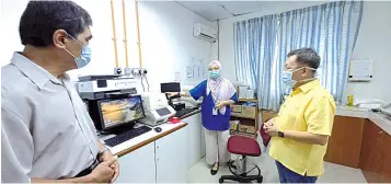  ??  ?? Dr Sim (right) and Sarawak Health director Dr Chin Zin Hing (left) visit a Covid-19 testing lab at Sarawak General Hospital. — Photo from Dr Sim