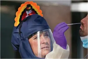  ?? PHOTO: RICK BOWMER/AP ?? Costume: Public-health nurse Lee Cherie Booth administer­s a coronaviru­s test dressed as a turkey to celebrate Thanksgivi­ng in Salt Lake City.