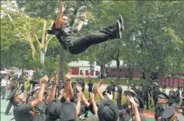  ?? PTI ?? Cadets celebratin­g after the passing-out parade at the Indian Military Academy, and (below) a cadet getting his mask adjusted.