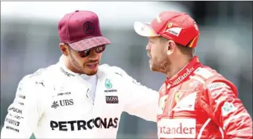  ?? MARK THOMPSON/GETTY IMAGES/AFP ?? Lewis Hamilton and Sebastian Vettel speak on Saturday during qualifying for the Canadian Grand Prix at Circuit Gilles Villeneuve in Montreal.