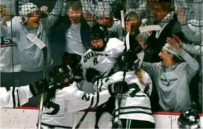  ?? KEN MCGACH FOR THE GLOBE ?? Duxbury’s Addy Harrington (center, No. 8) is the toast of her team after her third-period goal.